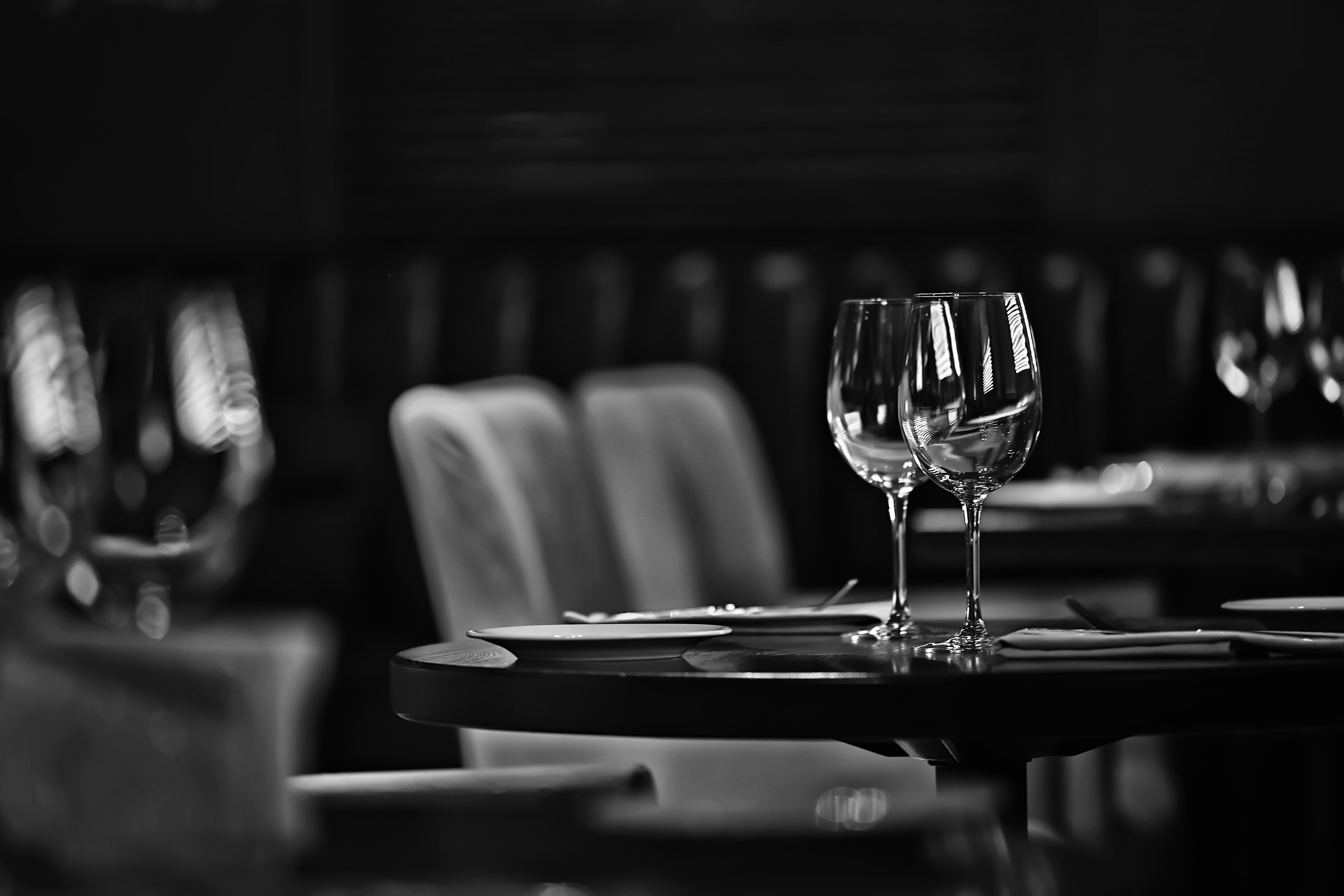 Black and white: a dining table set with two wine glasses.